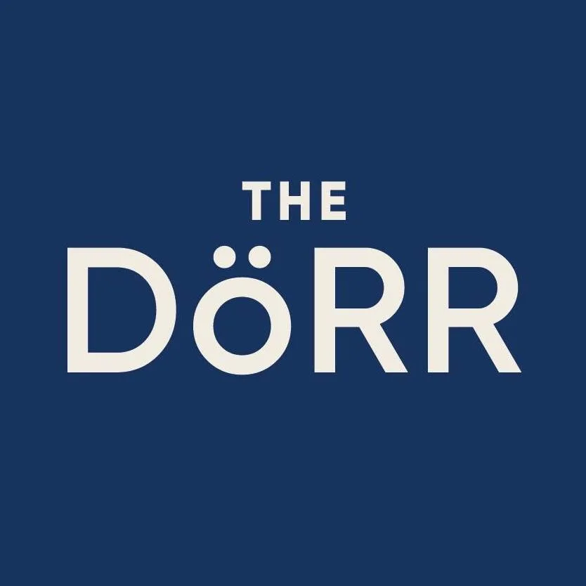 The Dorr Hotel logo featuring white text on a navy blue background, with an umlaut accent over the letter 'O' in 'DÖRR'.